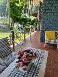 a table with a bouquet of pink roses on it at Seaside Cottage in Paralia Katerinis
