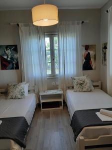 a small room with two beds and a window at Seaside Cottage in Paralia Katerinis
