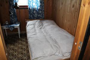 a small bed in a small room with a window at Fjøset in Hansnes