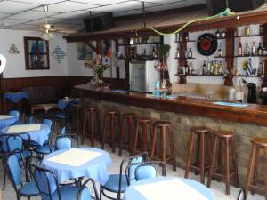 a restaurant with tables and chairs and a bar at Hotel Theo in Panagia