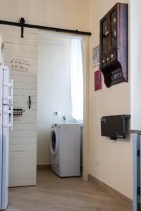Baño con lavadora y secadora junto a una puerta en Un letto nel cortile, en Bereguardo