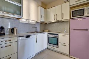 una cocina con electrodomésticos blancos y armarios blancos en Academia en Rodas