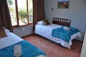 a bedroom with two beds and a window at 14 Cluster House & Studio in George