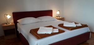 a bedroom with a bed with two towels on it at Apartments Rubinić in Jelsa