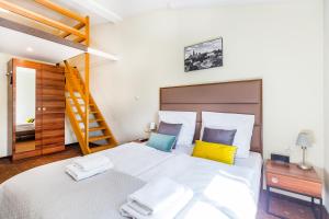 sypialnia z dużym białym łóżkiem z żółtymi i niebieskimi poduszkami w obiekcie Aparthotel Old Town w Krakowie