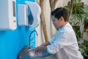 a young boy washing his hands in a sink at Hosteria Las Quintas Hotel Restaurante Bar in Cuernavaca