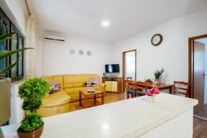 sala de estar con sofá amarillo y mesa en Casa Nina en Neum