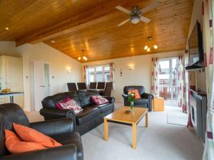 a living room with leather furniture and a wooden ceiling at Finest Retreats - Whitsand Bay Lodge in Torpoint