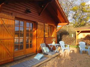 une cabane en bois avec deux chaises et une table dans l'établissement Gîte de l'Oursonnière, à Saint-Laurent-dʼOingt