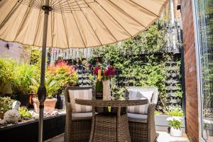 a table and chairs with an umbrella on a patio at The Garden Apartment in Deal