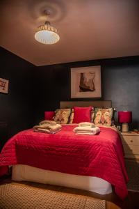 a bedroom with a red bed with a red blanket at The Garden Apartment in Deal