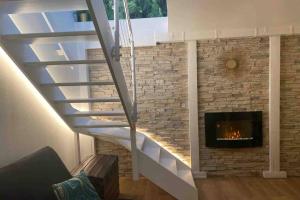 uma escada numa sala de estar com lareira em SPA de charme 6 pers avec Jacuzzi & Sauna privatifs au coeur de ville - Esprit Coco em Mulhouse