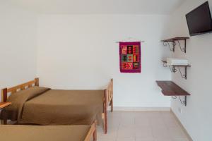 1 dormitorio con 1 cama y TV en la pared en Aires de Cafayate en Cafayate