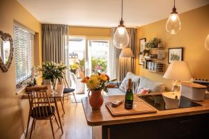 uma cozinha e sala de estar com uma mesa com flores em The Garden Apartment em Deal