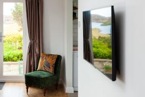 a green chair in front of a mirror at Grey Goose Cottage in Lochs