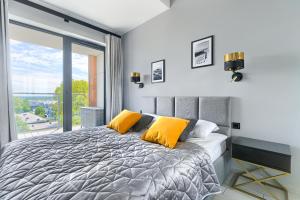 1 dormitorio con 1 cama grande con almohadas amarillas en Natural Apartamenty en Darlowko