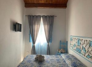un dormitorio con una cama con un animal de peluche en BnB Le Janas, en Cabras