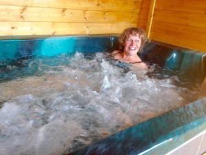 a woman is sitting in a hot tub at Les Maitres Sonneurs in Huriel
