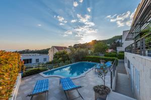 a swimming pool with two chairs and a table on a balcony at Villa Steffi in Baška Voda