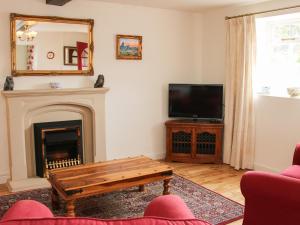 a living room with a fireplace and a tv at The Hayloft in Shelve