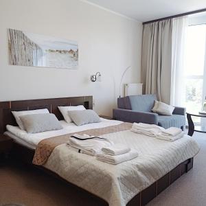 una camera con due letti e asciugamani di Apartament Promenada Park Kołobrzeg a Kołobrzeg