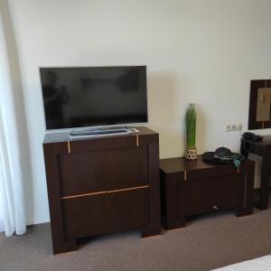 a flat screen tv sitting on top of a wooden entertainment center at Apartament Promenada Park Kołobrzeg in Kołobrzeg