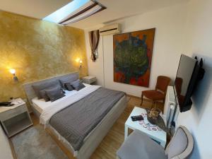 um quarto com uma cama, uma TV e uma mesa em TEPIĆ Garni Hotel em Temerin