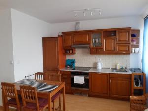 a kitchen with wooden cabinets and a wooden table with a tableablish at Na Złotych Łanach - apartament z parkingiem in Bielsko-Biała