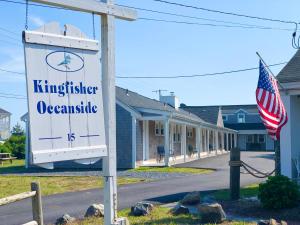 um sinal em frente a uma casa com uma bandeira americana em Kingfisher Oceanside em Dennis Port