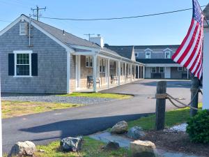 ein Haus mit amerikanischer Flagge davor in der Unterkunft Kingfisher Oceanside in Dennis Port