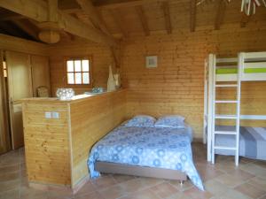 - une chambre avec un lit dans une cabane en bois dans l'établissement Gîte de l'Oursonnière, à Saint-Laurent-dʼOingt