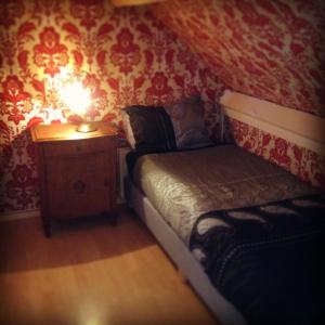 een kleine slaapkamer met een bed en een tafel met een lamp bij Huisje Stockholm op Terschelling in West-Terschelling
