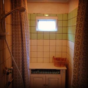 een kleine badkamer met een raam en een douche bij Huisje Stockholm op Terschelling in West-Terschelling