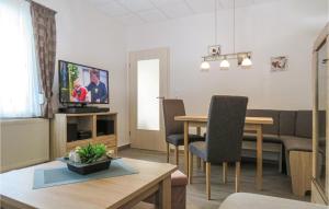 uma sala de estar com uma televisão e uma mesa e cadeiras em Awesome Home In Blankenburg Harz With Kitchen em Blankenburg