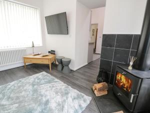 a living room with a fireplace and a stove at 2 Mountain View in Llangefni