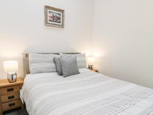 a bedroom with a large white bed with two lamps at 2 Mountain View in Llangefni