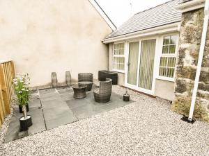 a patio with chairs and a table in front of a house at 2 Mountain View in Llangefni