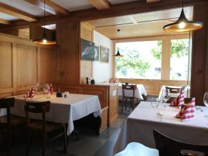 una sala da pranzo con due tavoli e una finestra di Hotel Alpenrose a Maienfeld