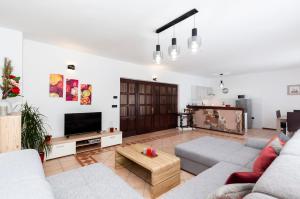 ein Wohnzimmer mit 2 Sofas und einem TV in der Unterkunft Apartment St. Antonio in Rovinj