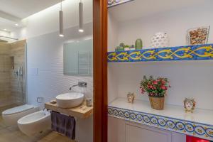 Un baño con dos lavabos, un inodoro y un espejo. en Vento di Scirocco, en Marsala 36 fotos más