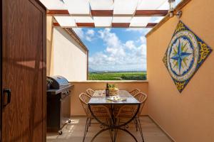 un pequeño balcón con mesa, sillas y ventana en Vento di Scirocco, en Marsala