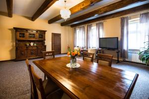 a dining room with a wooden table and a television at Rynek 7 - Apartamenty in Bielsko-Biała