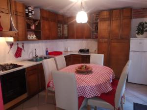 a kitchen with a table with a red and white table cloth at Pineta in Gračišče