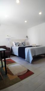 a bedroom with a large bed and a table at Tomarhousing - Studio in Tomar