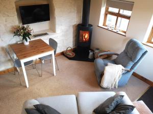 a living room with a couch and a wood stove at The Byre in Llandyfrydog