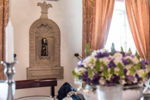 a vase of purple flowers on a table with a statue at Private Nature Villa with Saltwater Pool in North Portugal in Cabeceiras de Basto