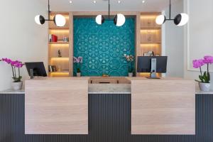 an office with a reception desk with a green wall at Boutique Hotel Momentum by Aycon in Budva