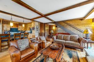 una sala de estar con muebles de cuero y una escalera. en Slopeside Sanctuary, en Copper Mountain