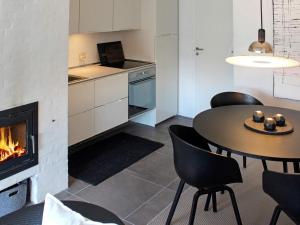 ein Wohnzimmer mit einem Tisch und einem Kamin in der Unterkunft 4 person holiday home in Bl vand in Blåvand