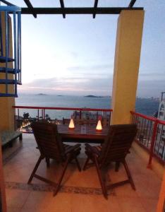 una mesa y sillas en un balcón con vistas al océano en Precioso ático con solárium y vistas fantásticas, en Playa Honda